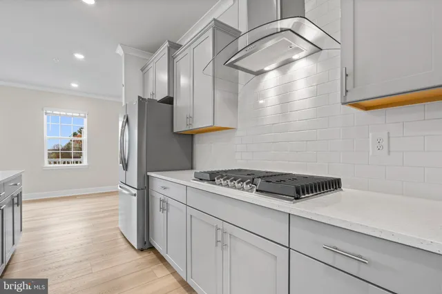 a kitchen with a stove and a wooden floor