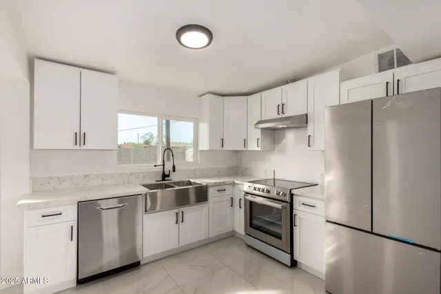 a kitchen with white cabinets and white appliances