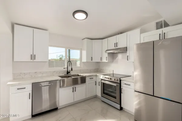 a kitchen with white cabinets and white appliances