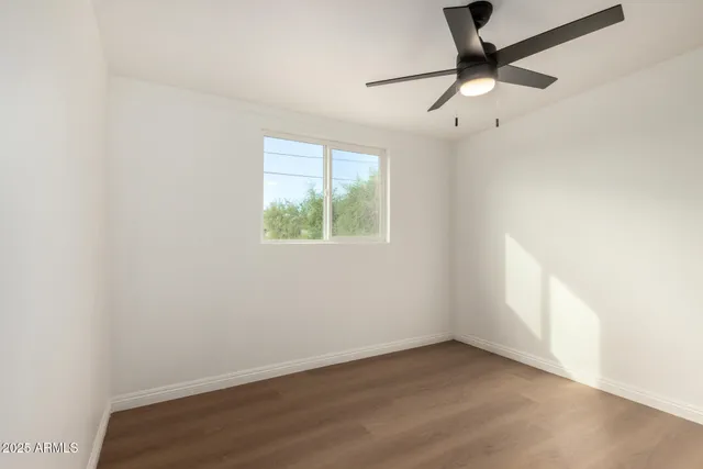 an empty room with a window and a fan