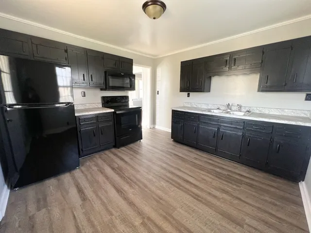 a large kitchen with stainless steel appliances granite countertop a stove a sink dishwasher and a refrigerator