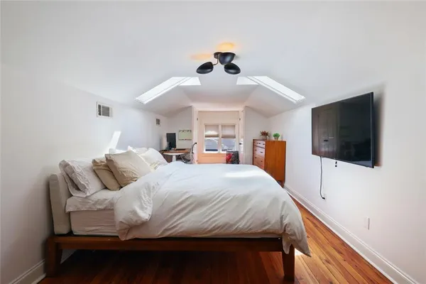 a bedroom with a large bed and a flat screen tv