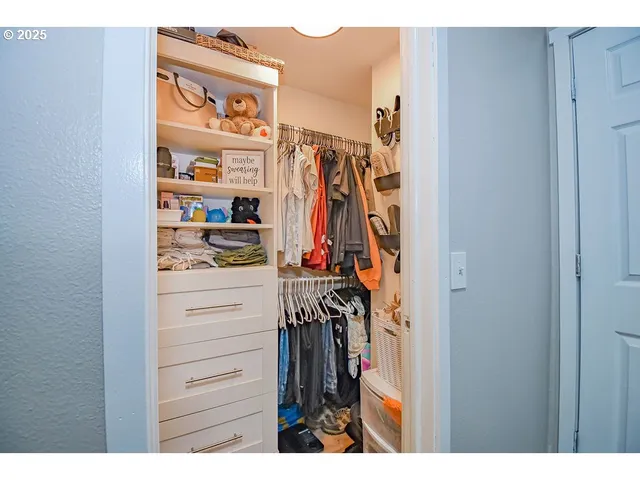 a view of walk in closet with clothes