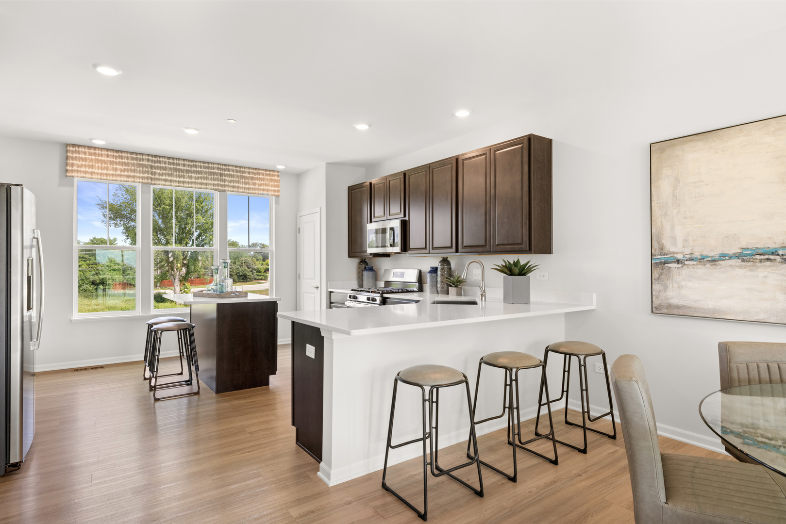 563 Wolverine Drive Aurora, IL 60502 - Photo 6 of 30 a kitchen with stainless steel appliances granite countertop a refrigerator a stove top oven a sink dishwasher and white cabinets with wooden floor
