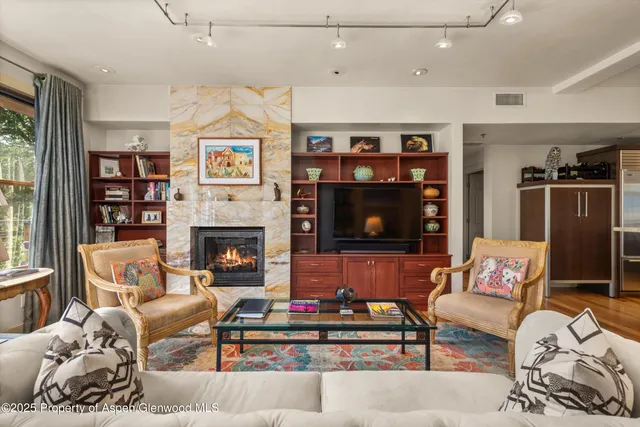 a living room with furniture a flat screen tv and a fireplace
