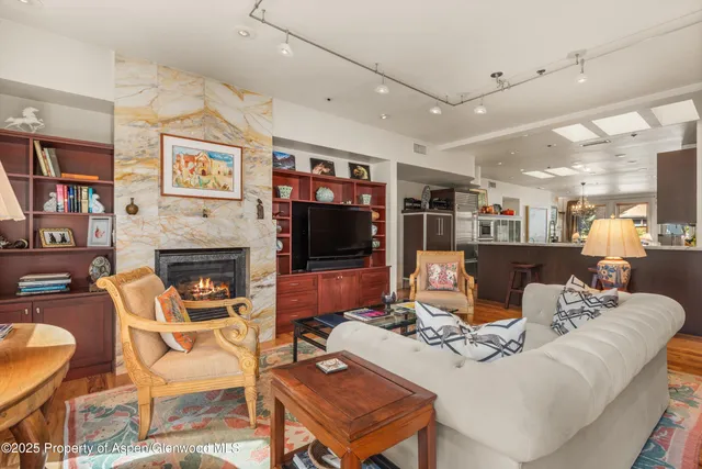 a living room with furniture a flat screen tv and a book shelf