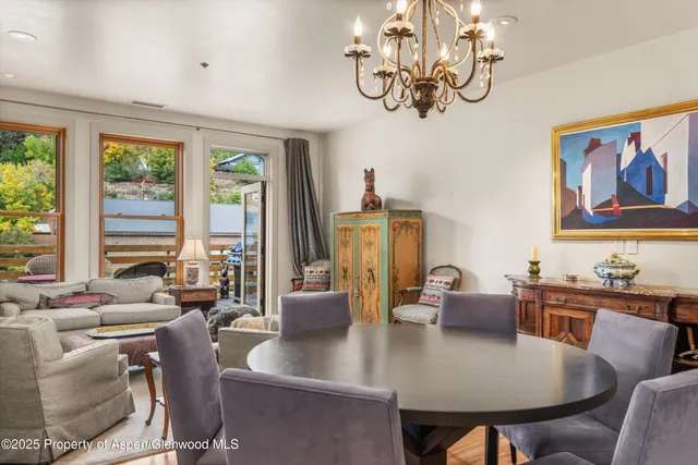 a view of a dining room with furniture a chandelier and wooden floor