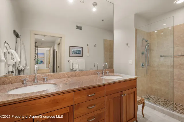 a bathroom with a granite countertop toilet sink and mirror