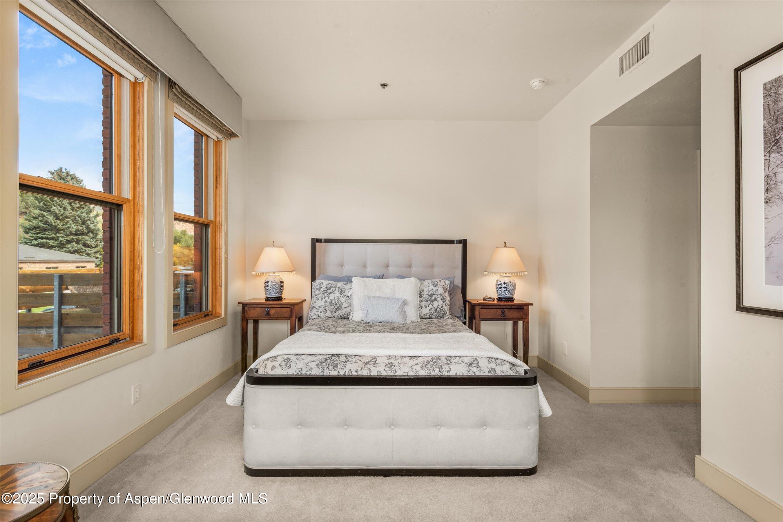 227 Midland Avenue, Unit 22 Basalt, CO 81621 - Photo 39 of 42 a bedroom with a bed lamp and a large window