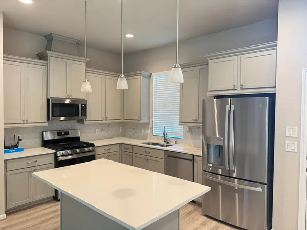 a kitchen with white cabinets and stainless steel appliances