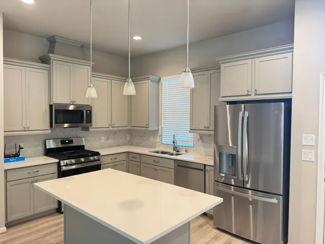 a kitchen with white cabinets and stainless steel appliances