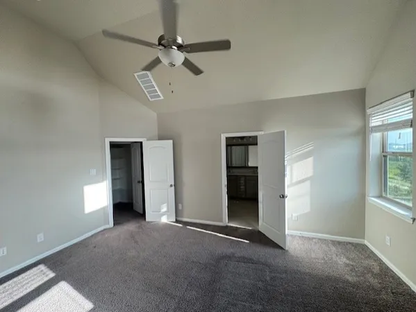 an empty room with windows and fan