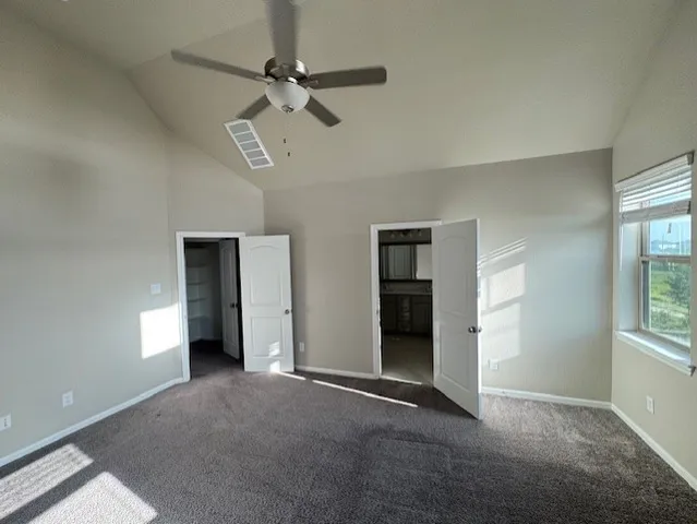 an empty room with windows and fan