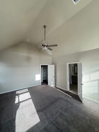 an empty room with windows and fireplace