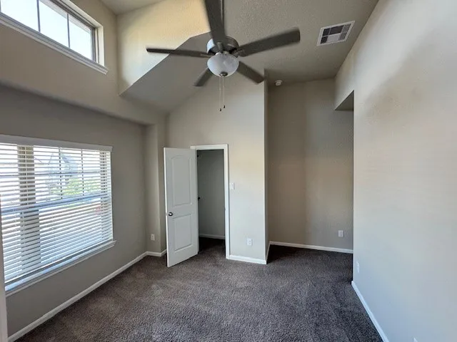 an empty room with windows and fan