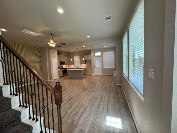 a view of a hallway with wooden floor and staircase