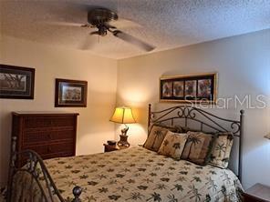 6807 Stone River Road, Unit 202 Bradenton, FL 34203 - Photo 3 of 12 a bedroom with a bed and a chandelier