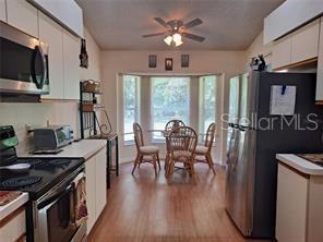 6807 Stone River Road, Unit 202 Bradenton, FL 34203 - Photo 9 of 12 a view of a dining room with furniture window and wooden floor