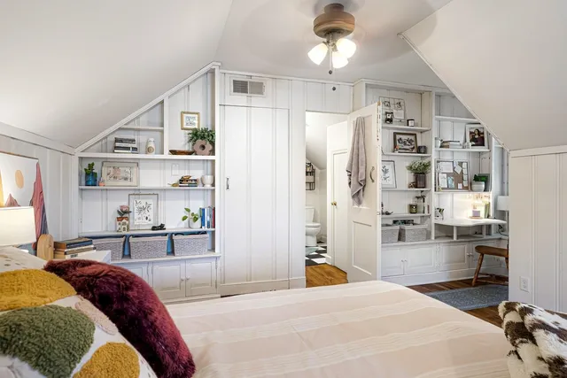 a bedroom with a bed furniture a chandelier and closet