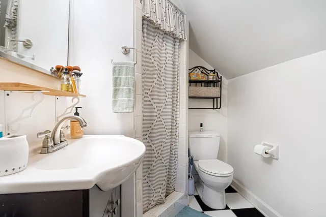 a bathroom with a toilet a sink and mirror