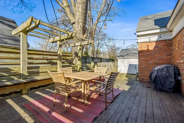 a view of a patio with table and chairs with wooden floor and fence