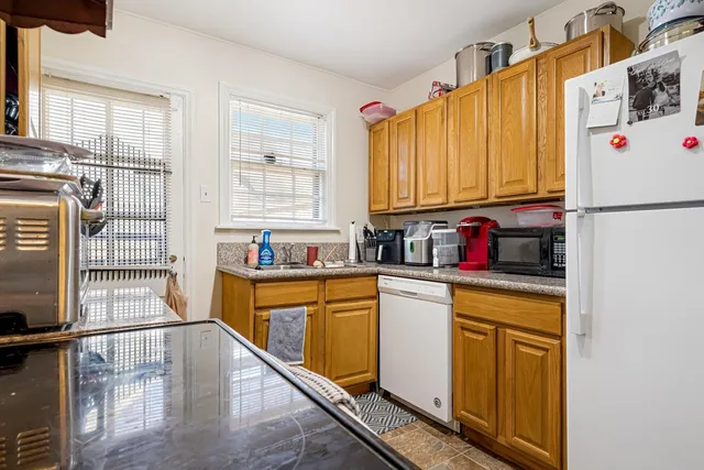 a kitchen with stainless steel appliances granite countertop a refrigerator sink stove and white cabinets