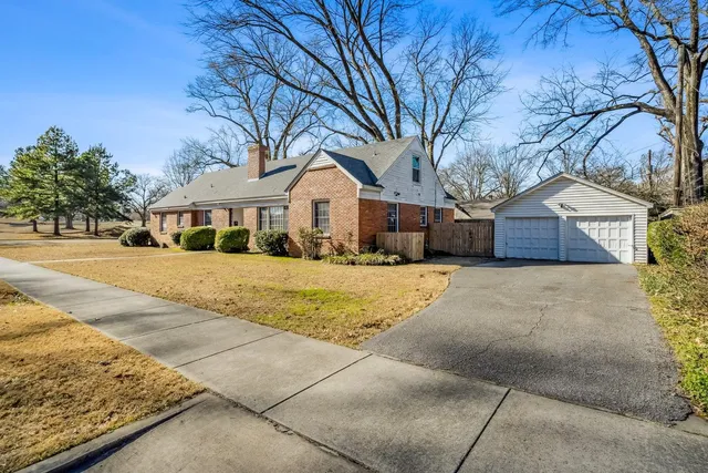 a front view of house with yard and trees around
