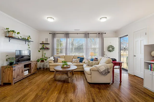 a living room with furniture and wooden floor