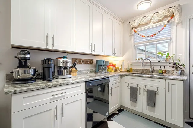 a kitchen with granite countertop white cabinets and white stainless steel appliances