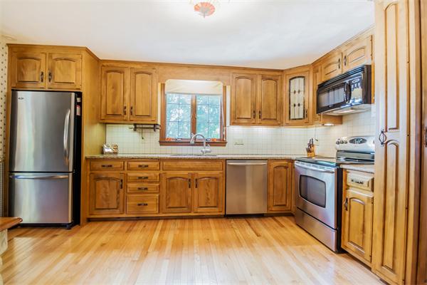 6 James Road Reading, MA 01867 - Photo 8 of 30 a kitchen with stainless steel appliances granite countertop a refrigerator a stove top oven a sink and dishwasher