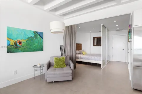 a bedroom with a bed and a painting on the wall