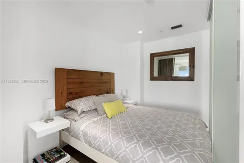 a bedroom with a bed and glass door