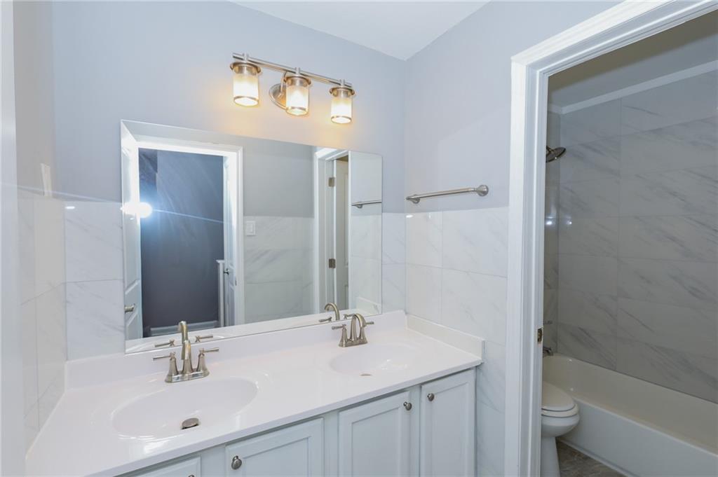 1277 Goodwin Road Northeast, Unit 1273 Atlanta, GA 30324 - Photo 14 of 19 a bathroom with a sink a toilet and shower