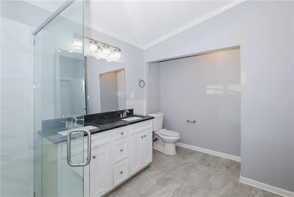 a spacious bathroom with a granite countertop sink toilet and mirror