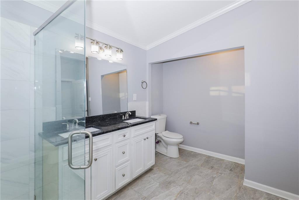 1277 Goodwin Road Northeast, Unit 1273 Atlanta, GA 30324 - Photo 15 of 18 a spacious bathroom with a granite countertop sink a toilet and a mirror