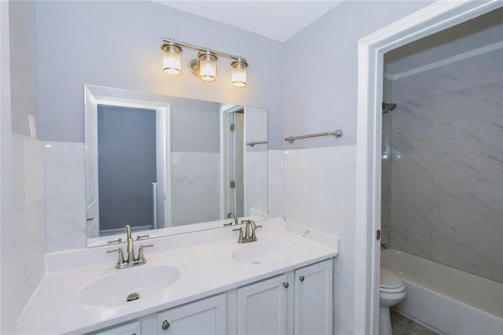 1277 Goodwin Road Northeast, Unit 1273 Atlanta, GA 30324 - Photo 16 of 18 a bathroom with a sink a toilet and shower