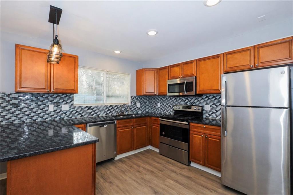 1277 Goodwin Road Northeast, Unit 1273 Atlanta, GA 30324 - Photo 8 of 18 a kitchen with stainless steel appliances granite countertop a refrigerator a sink dishwasher a stove with wooden floor