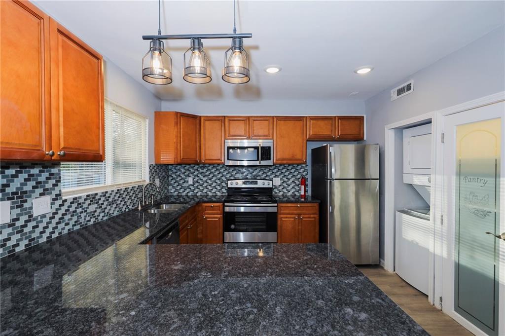 1277 Goodwin Road Northeast, Unit 1273 Atlanta, GA 30324 - Photo 9 of 18 a kitchen with stainless steel appliances granite countertop a refrigerator a sink dishwasher a oven with large cabinets and wooden floor