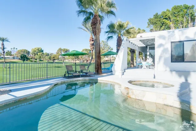 a view of a house with a swimming pool and a yard