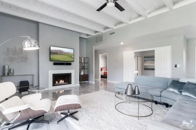 a living room with furniture a fireplace and a flat screen tv