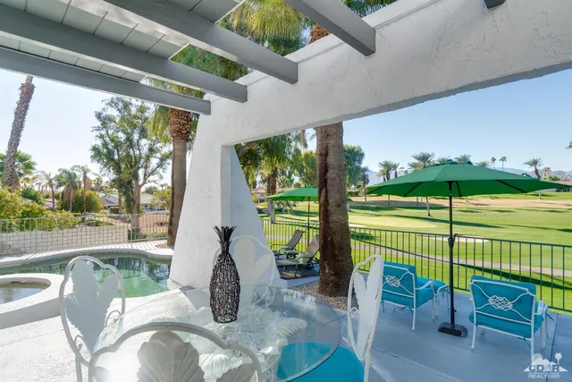 a view of a patio with table and chairs potted plants with wooden floor and fence