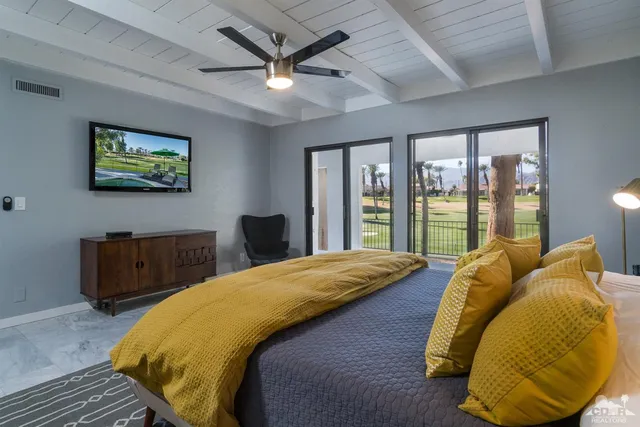 a bedroom with a bed and a large window