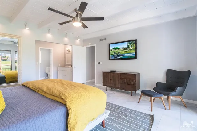 a bedroom with a bed and a chair with the bookshelf