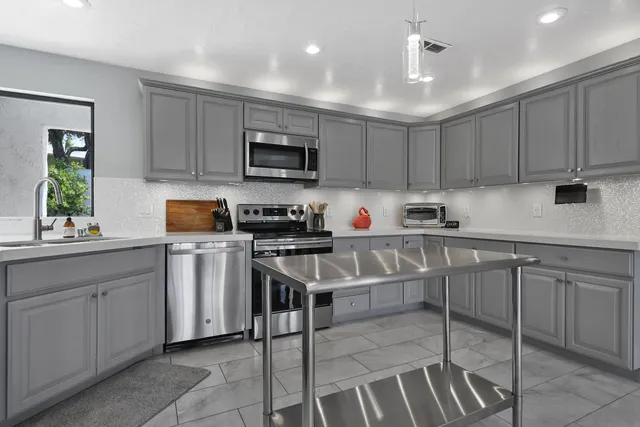 a kitchen with a sink a microwave and cabinets