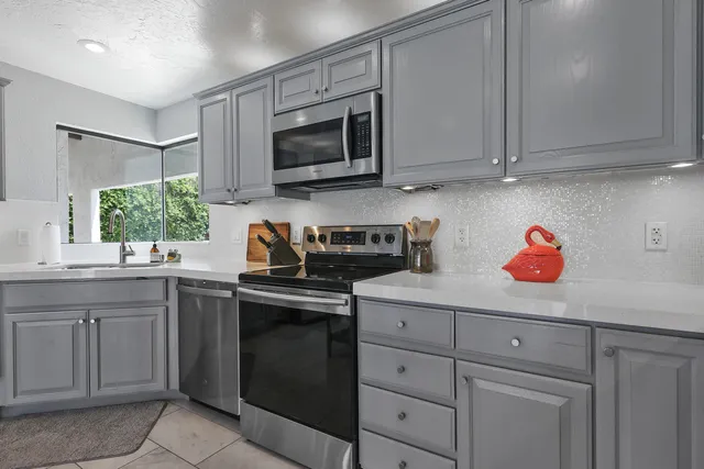 a kitchen with stainless steel appliances granite countertop white cabinets and a stove