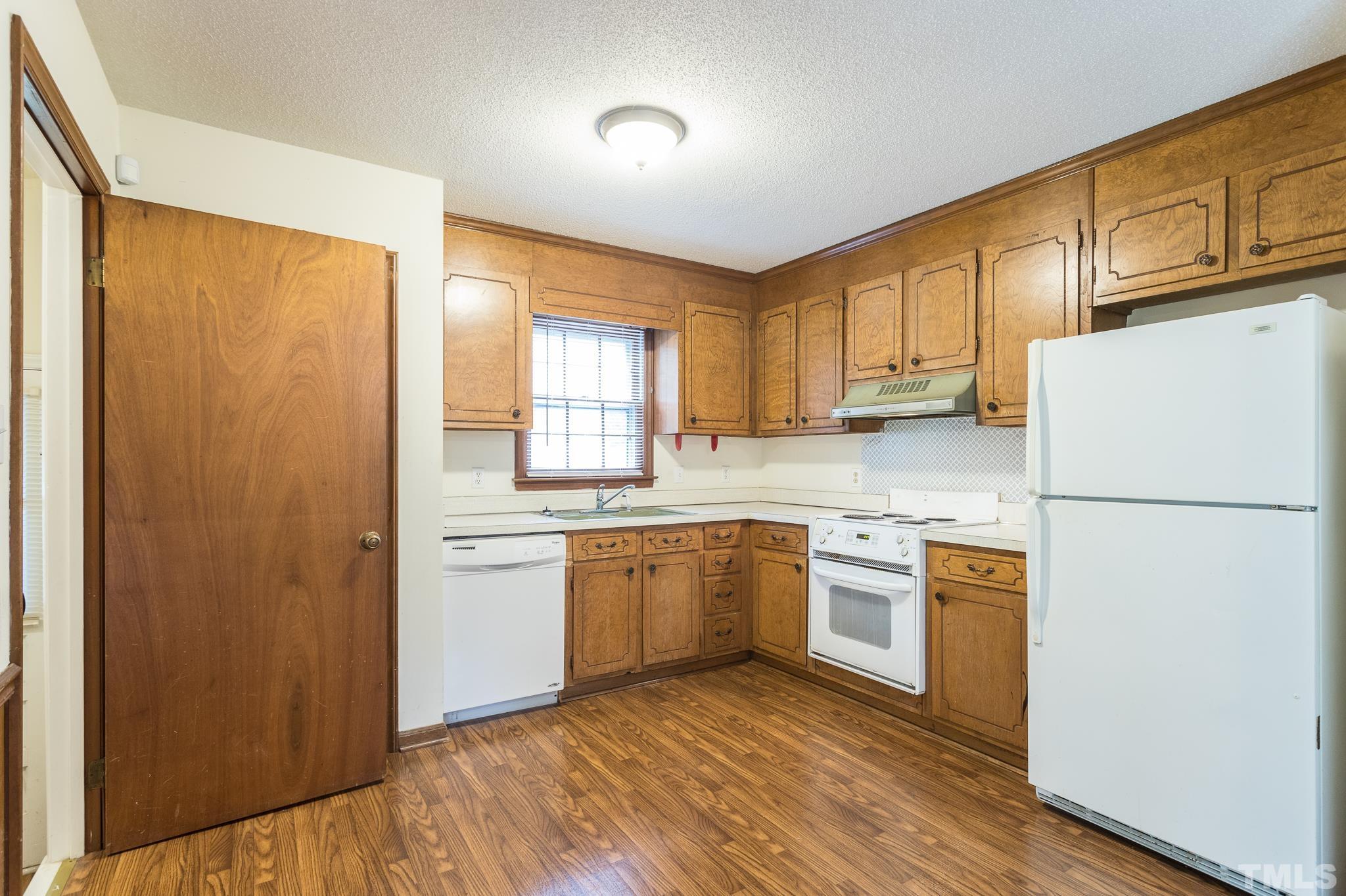 4413 Kilcullen Drive Raleigh, NC 27604 - Photo 15 of 21 a kitchen with a sink a refrigerator a microwave and cabinets
