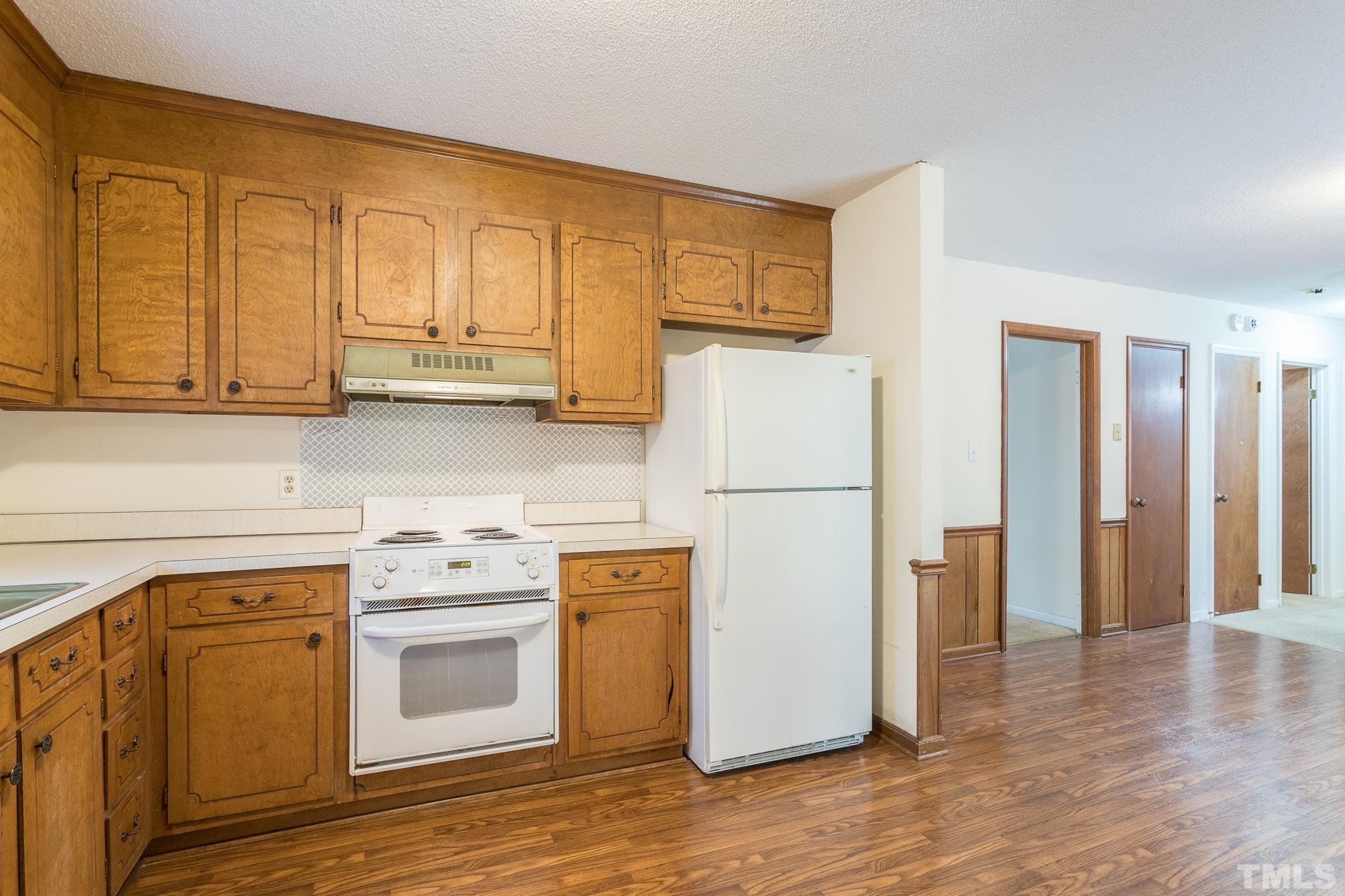 4413 Kilcullen Drive Raleigh, NC 27604 - Photo 18 of 21 a kitchen with a refrigerator sink stove and cabinets