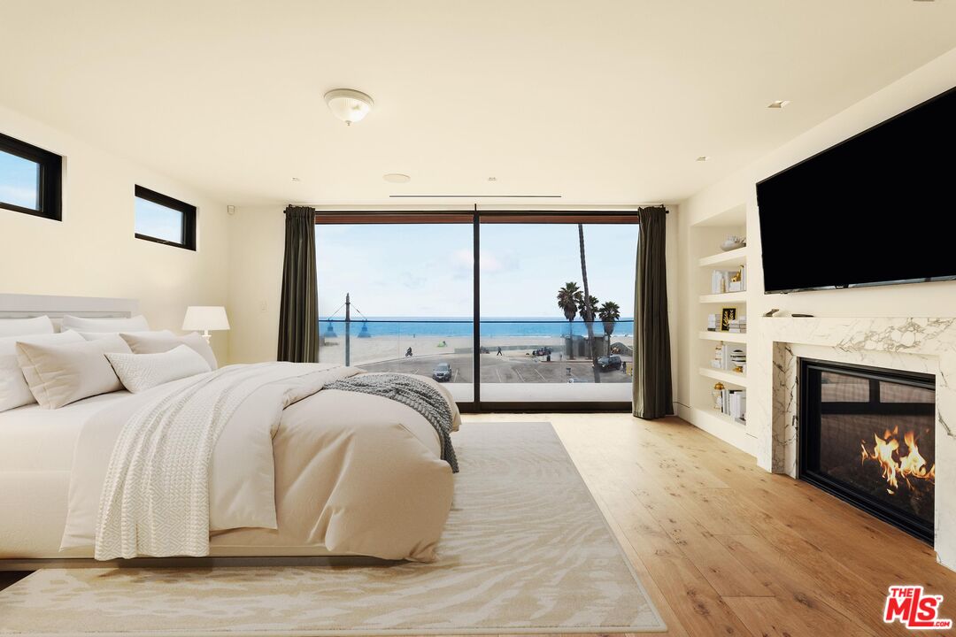 2205 Ocean Front Walk Venice, CA 90291 - Photo 15 of 30 a spacious bedroom with a bed and a fireplace with a flat tv screen