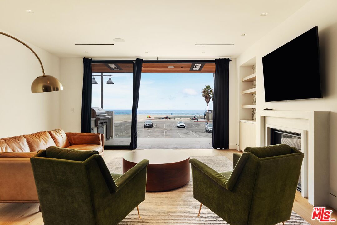 2205 Ocean Front Walk Venice, CA 90291 - Photo 10 of 30 a living room with fireplace a flat screen tv and a fireplace