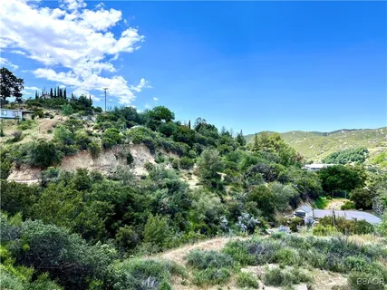 an aerial view of residential house with outdoor space and trees all around